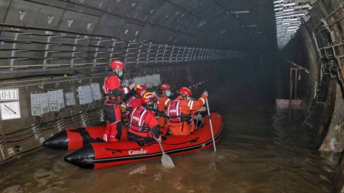 Bombeiros de bote em metrô inundado em Zhengzhou, na província chinesa de Henan Foto: STR / AFP