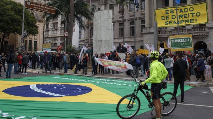 Ciclista aguarda a leitura das cartas pela democracia, em frente Faculdade de Direito do Largo São Francisco, na quinta-feira (11), em São Paulo - Caio Guatelli