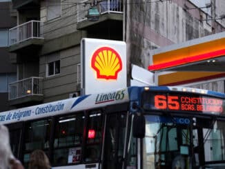 Pessoas caminham enquanto ônibus passa por um posto de gasolina Shell - Marcos Brindicci - 12.mar.18/Reuters