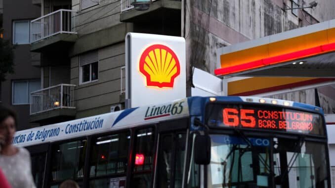 Pessoas caminham enquanto ônibus passa por um posto de gasolina Shell - Marcos Brindicci - 12.mar.18/Reuters